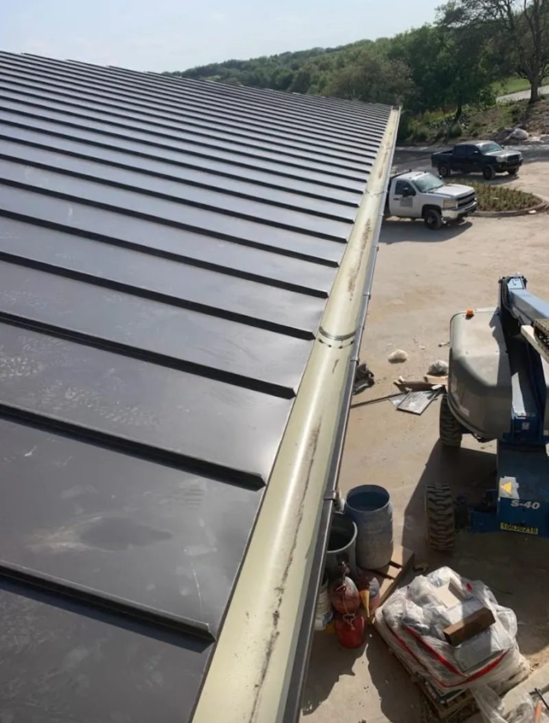 Standing seam panel and gutter detail on a metal roofing jobsite in Austin